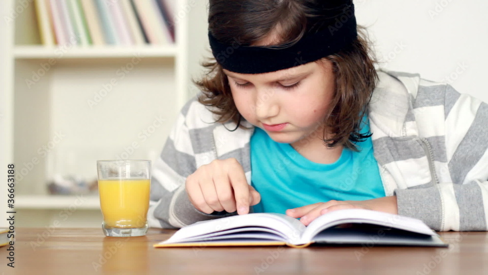 Young teenager reading book by the table, steadicam shot Young teenager reading book by the table, steadicam shot