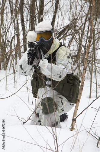 armed men in a camouflage play a paintball