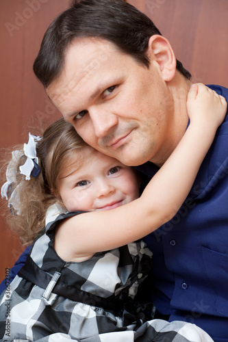 father with a daughter sit in a room on a floor