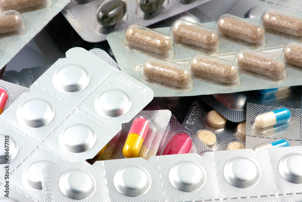 Pills of many shapes and colors grouped together