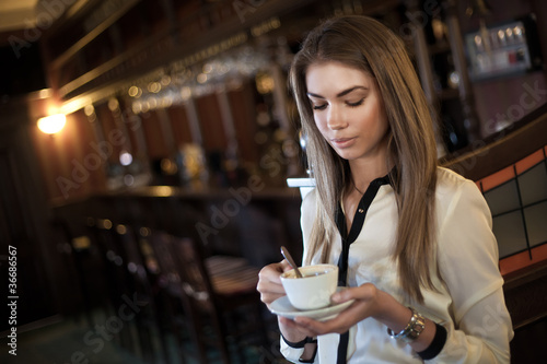 young beautiful woman in a cafe with a cup of coffee