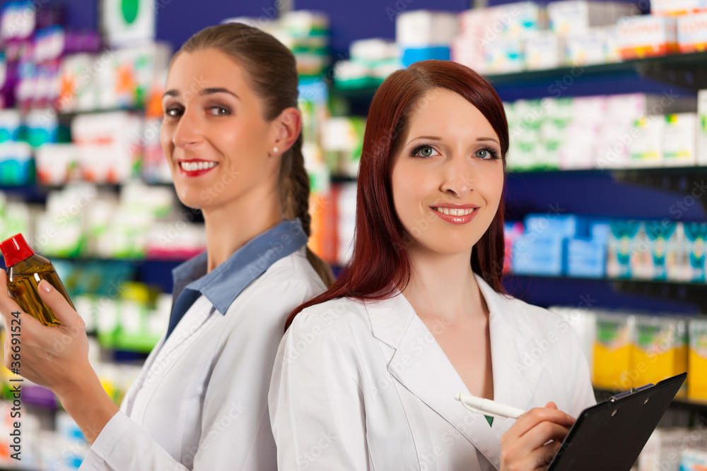 Apothekerin mit Apothekengehilfin in Apotheke Apothekerin mit Apothekengehilfin in Apotheke
