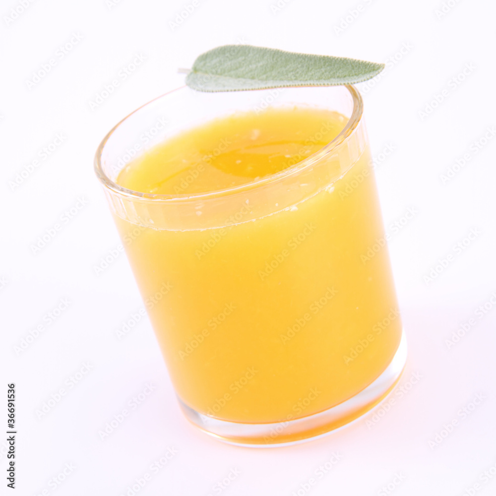 Orange juice, a glass decorated with salvia Orange juice, a glass decorated with salvia