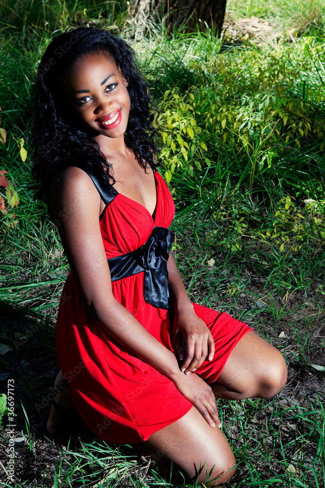 African American woman kneeling in grass outside Stock Photo | Adobe Stock