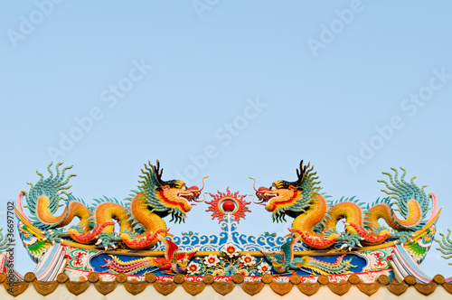 twin dragon on the roof of shrine with blue sky background