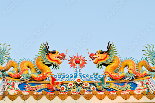 twin dragon on the roof of shrine with blue sky background © gamelover