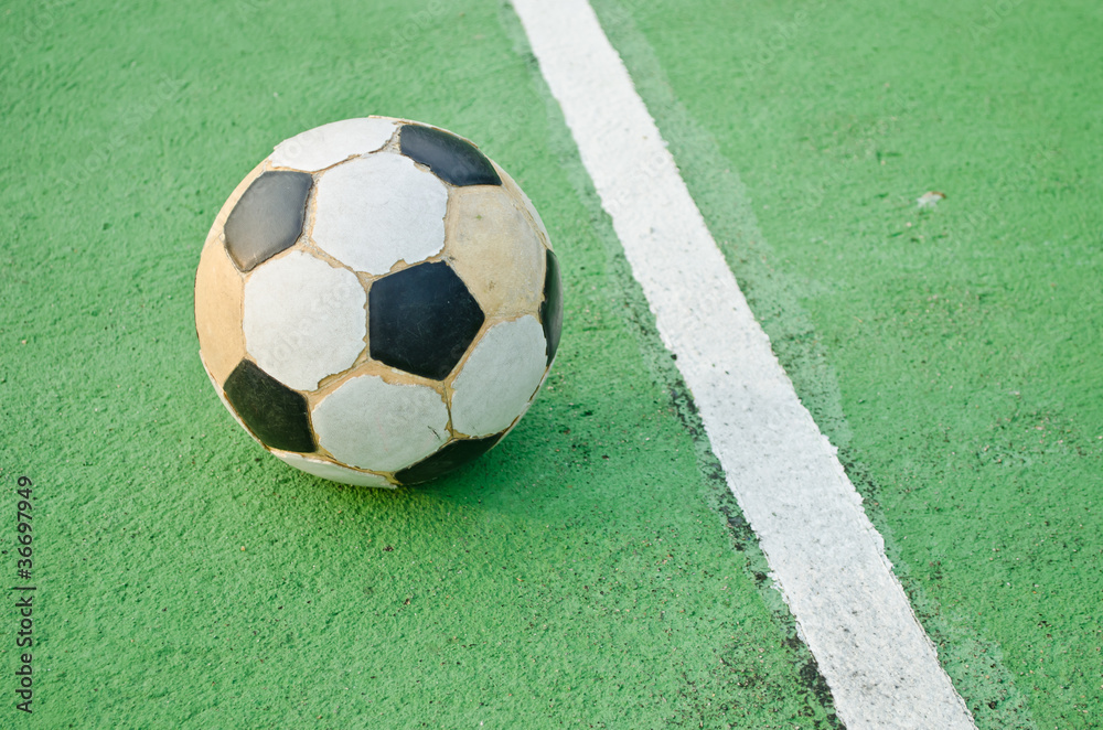 Fototapeta premium Old ball on green cement court