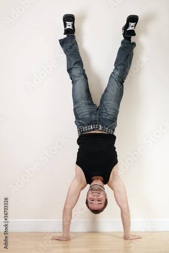 A joyful young man doing a handstand