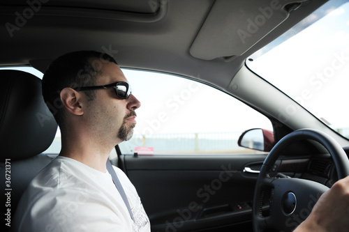 Man driving passenger car during the day