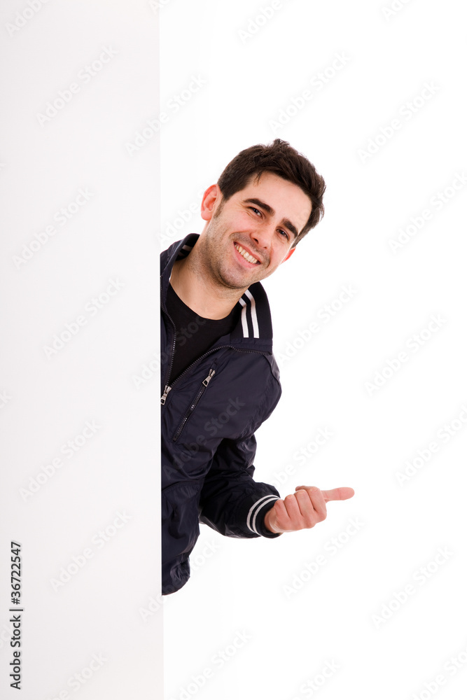 Happy young man showing thumbs up look out from white blank bann Happy young man showing thumbs up look out from white blank bann