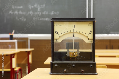 Educational galvanometer with not real number 555 on yellow desk photo