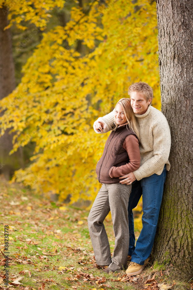 Autumn romantic couple smiling together in park Autumn romantic couple smiling together in park