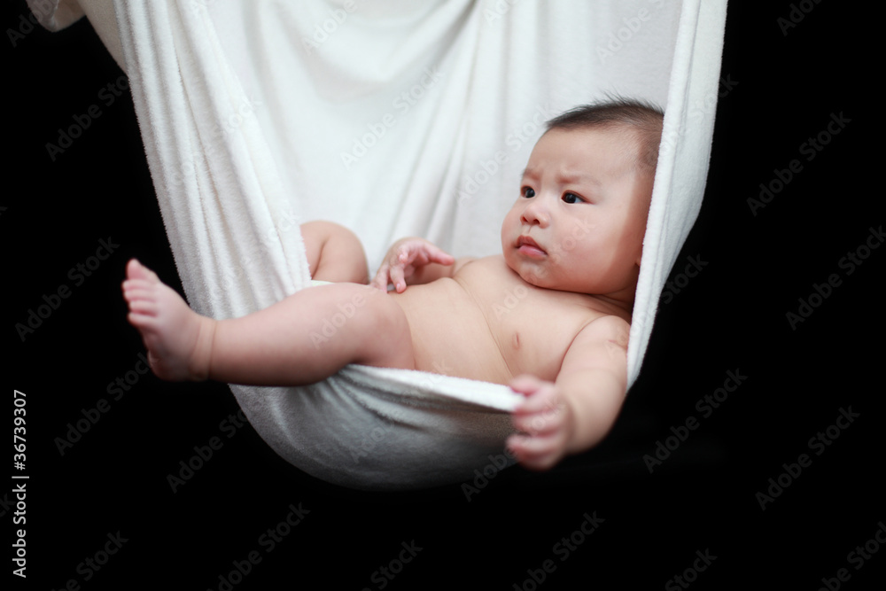Naked Baby sleeping in White Hammock Sling, isolated on a black