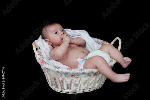 cute baby in  basket with black background