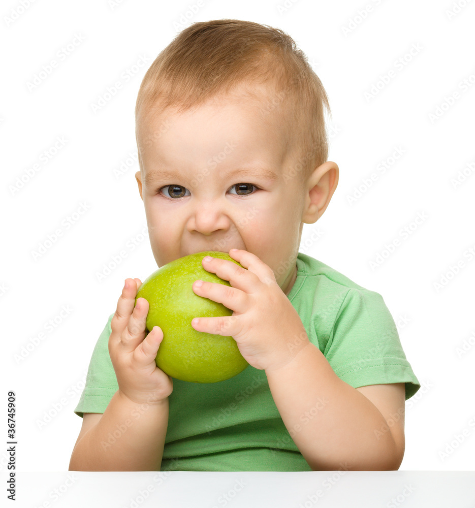 Little child is eating green apple Little child is eating green apple