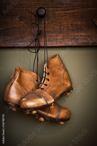 Vintage football boots hanging on a locker room