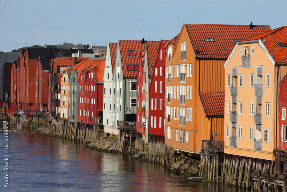 Row of colorful wooden houses beside the river in Trondheim