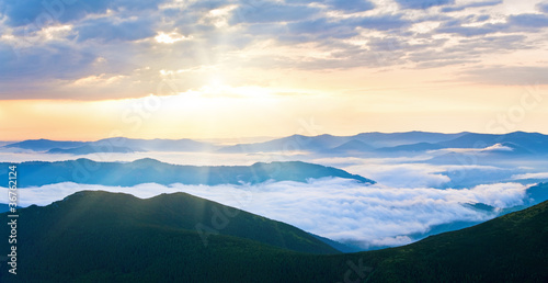 Summer cloudy sunrise mountain panorama © wildman