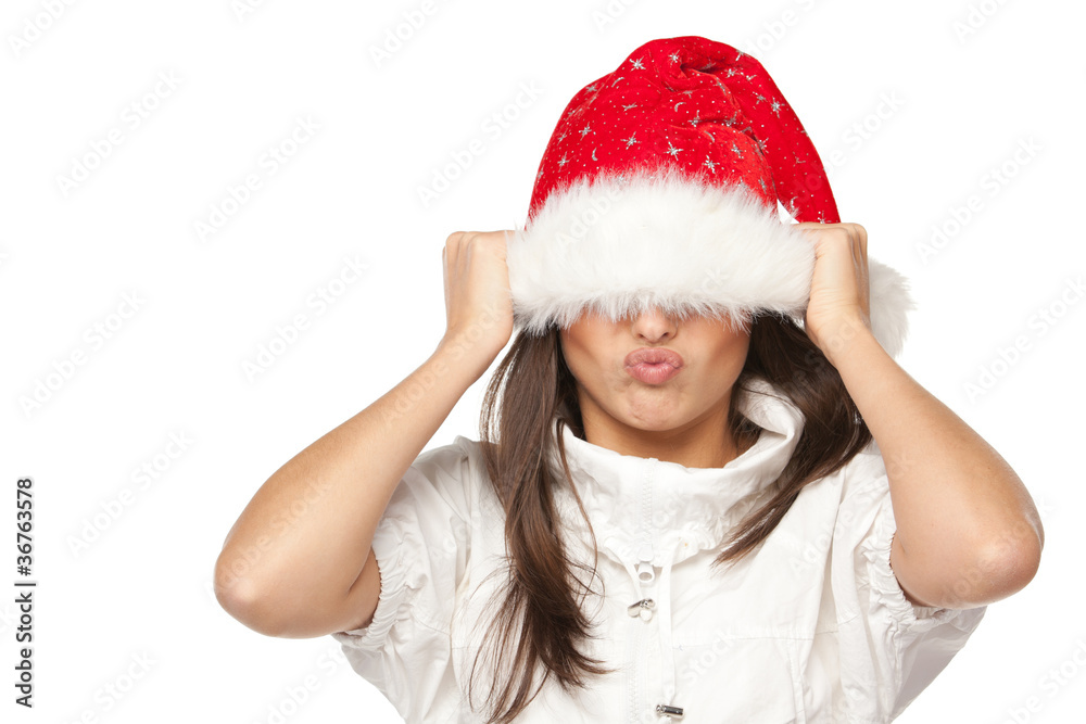 Girl in Santa hat having fun pulling down hat over eyes Girl in Santa hat having fun pulling down hat over eyes