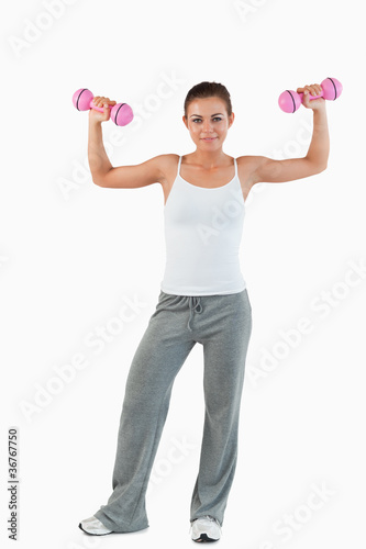 Portrait of a young woman working out with dumbbells