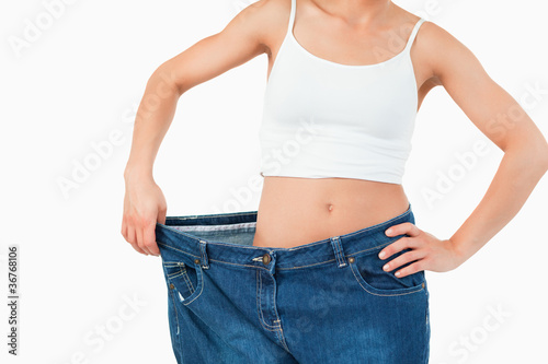 Thin woman wearing too large jeans