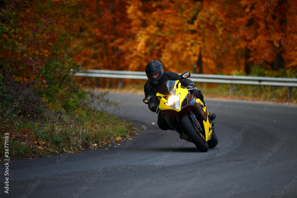 Naklejka premium man riding with speedbike in autumn