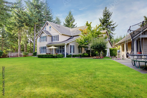 Large beige house with back yard