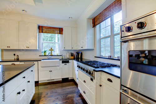 Luxury white kitchen with dark floors.