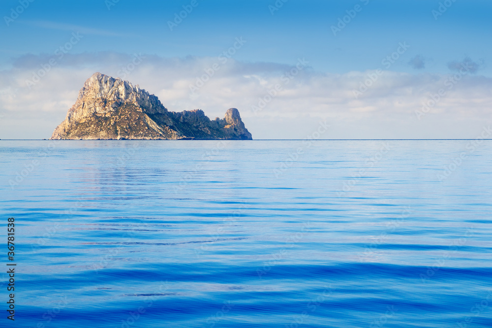 Ibiza Es Vedra island in calm blue water Ibiza Es Vedra island in calm blue water