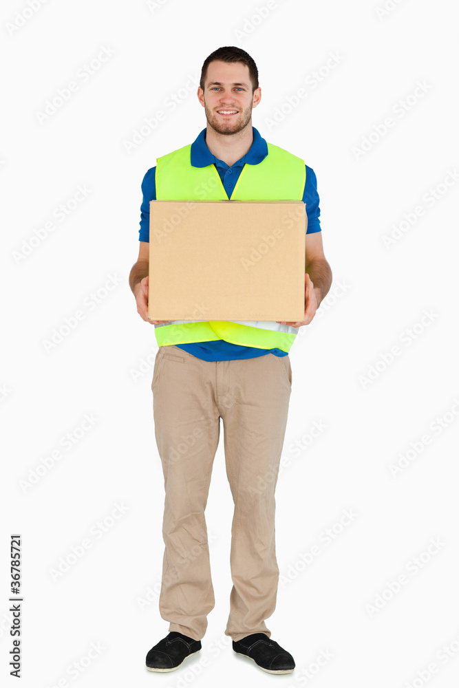 Smiling young delivery man carrying a parcel