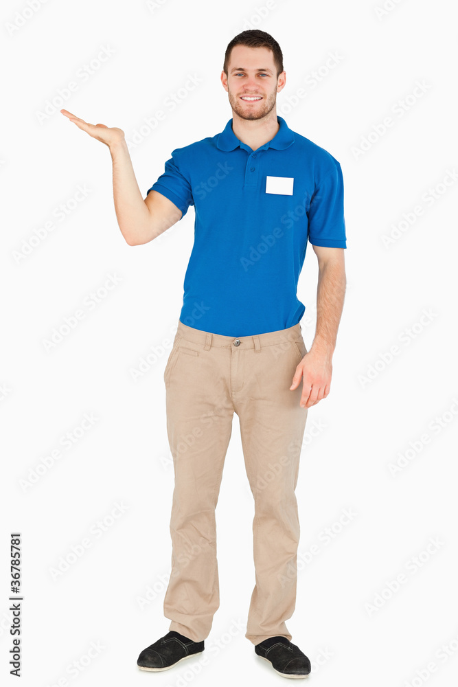 Smiling young salesman presenting in his palm Smiling young salesman presenting in his palm