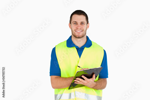 Фотография Smiling young delivery man completing delivery note