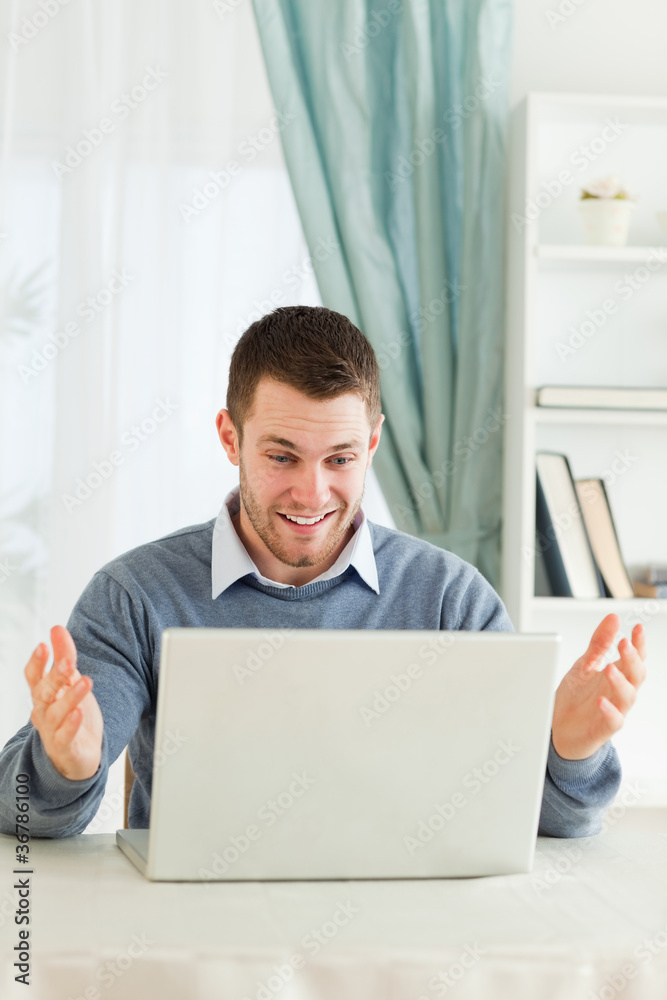 Businessman surprised about his laptop in his homeoffice Businessman surprised about his laptop in his homeoffice