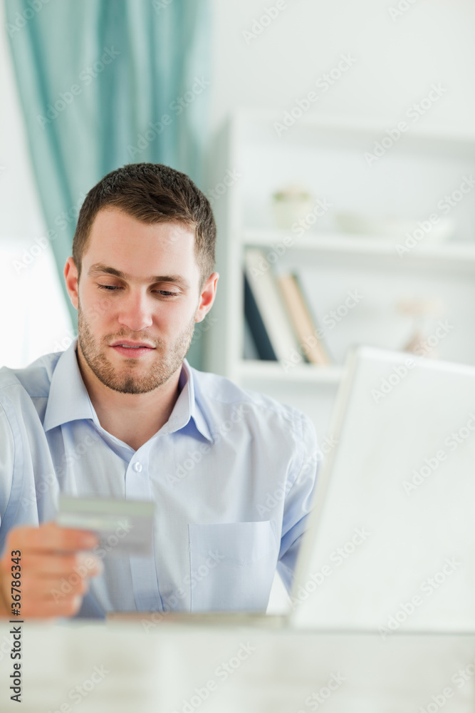Businessman with laptop and credit card in his homeoffice Businessman with laptop and credit card in his homeoffice