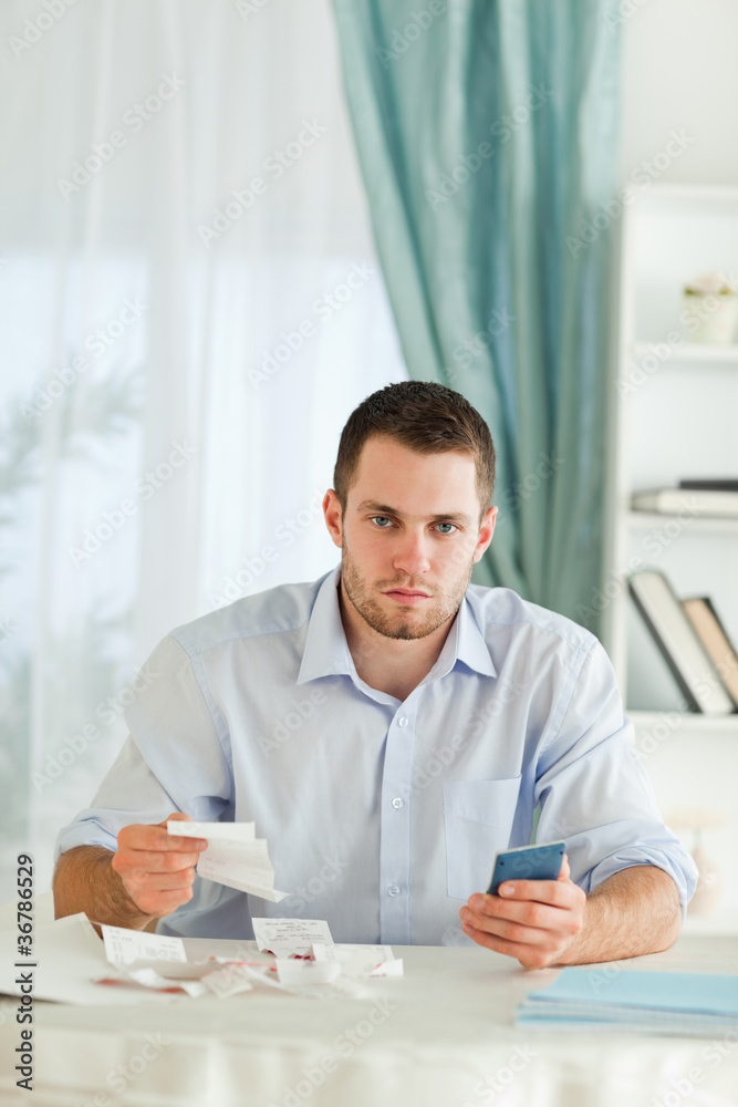 Serious looking businessman doing accounting Serious looking businessman doing accounting