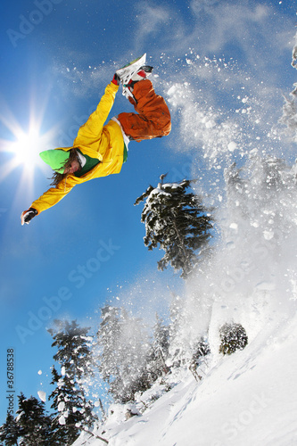 Snowboarder jumping against blue sky #36788538