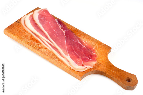 Jambon cru sur planche à découper photo