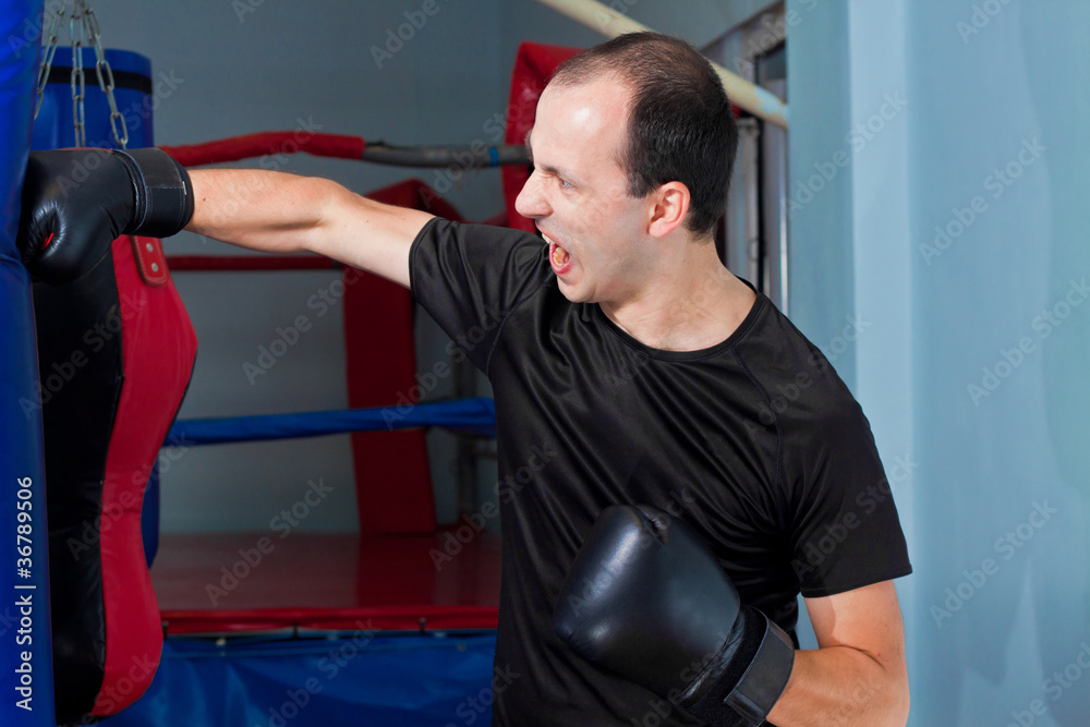 Boxer agressively punching a sand bag