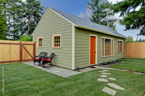 Small green and orange guest house in the back yard