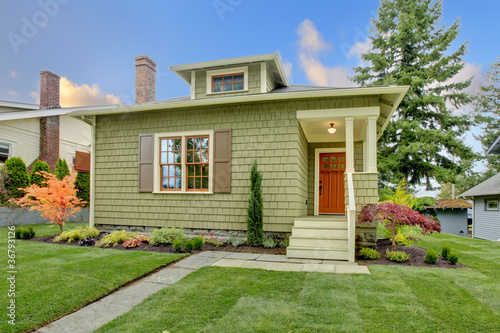 Green small craftsman style renovated house.