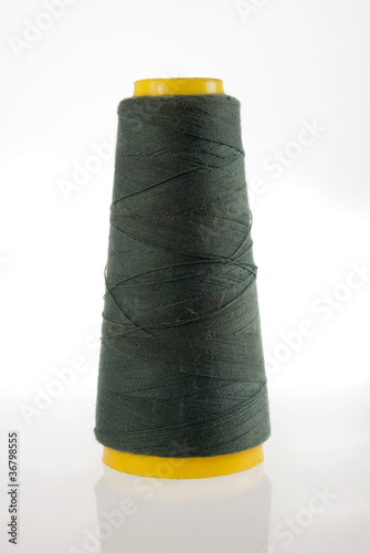 Spool of dark green thread isolated photo