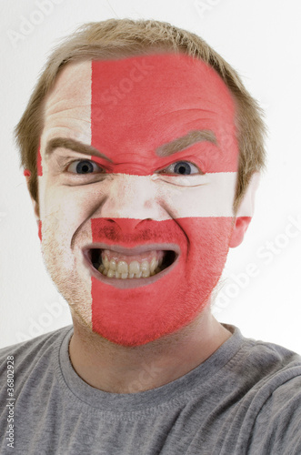 Face of crazy angry man painted in colors of denmark flag