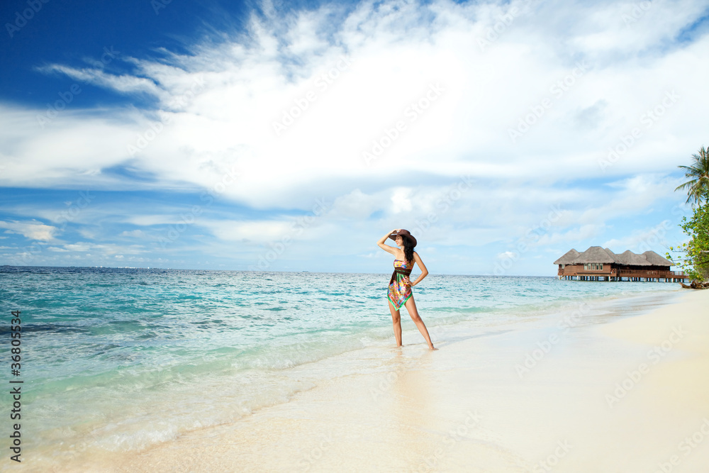 Tranquil woman on the tropical beach with bungalows Tranquil woman on the tropical beach with bungalows