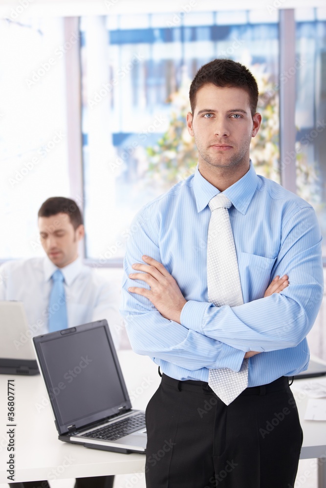 Confident businessman standing in bright office Confident businessman standing in bright office