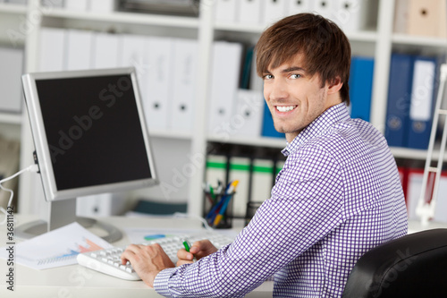 lächelnder geschäftsmann arbeitet am computer