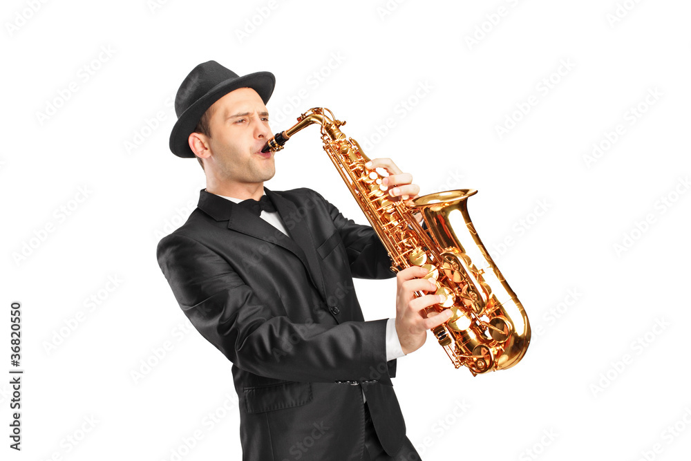 Naklejka premium Young man wearing hat and playing on saxophone