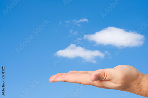 Hand in sky clouds background.
