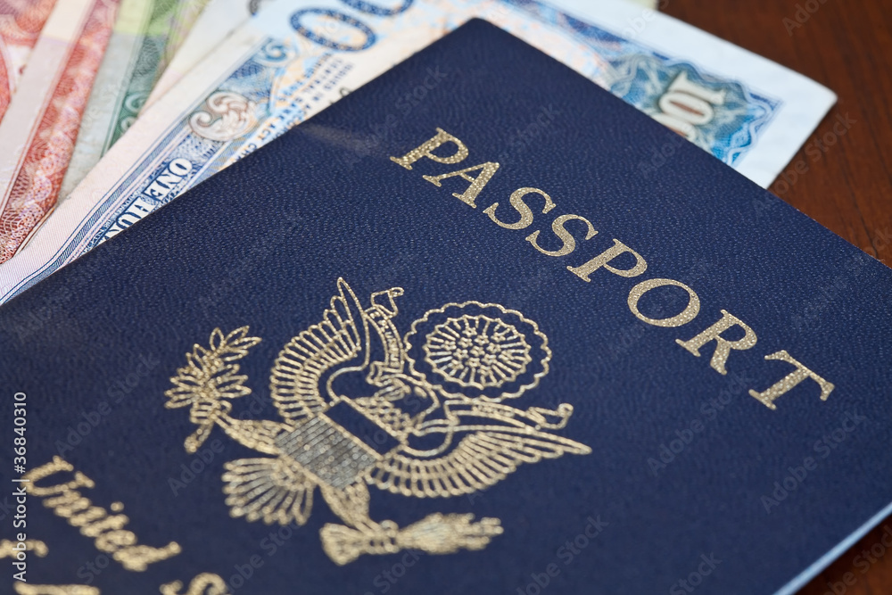 © Satori - Macro shot of passport and foreign currency