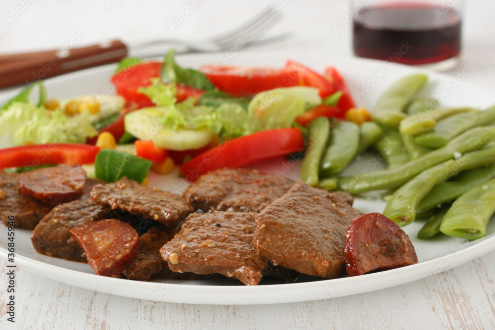 beef with sausages, beans and salad