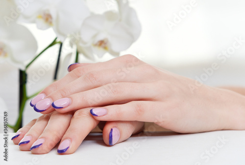 Design manicure close up on white orchid flower background
